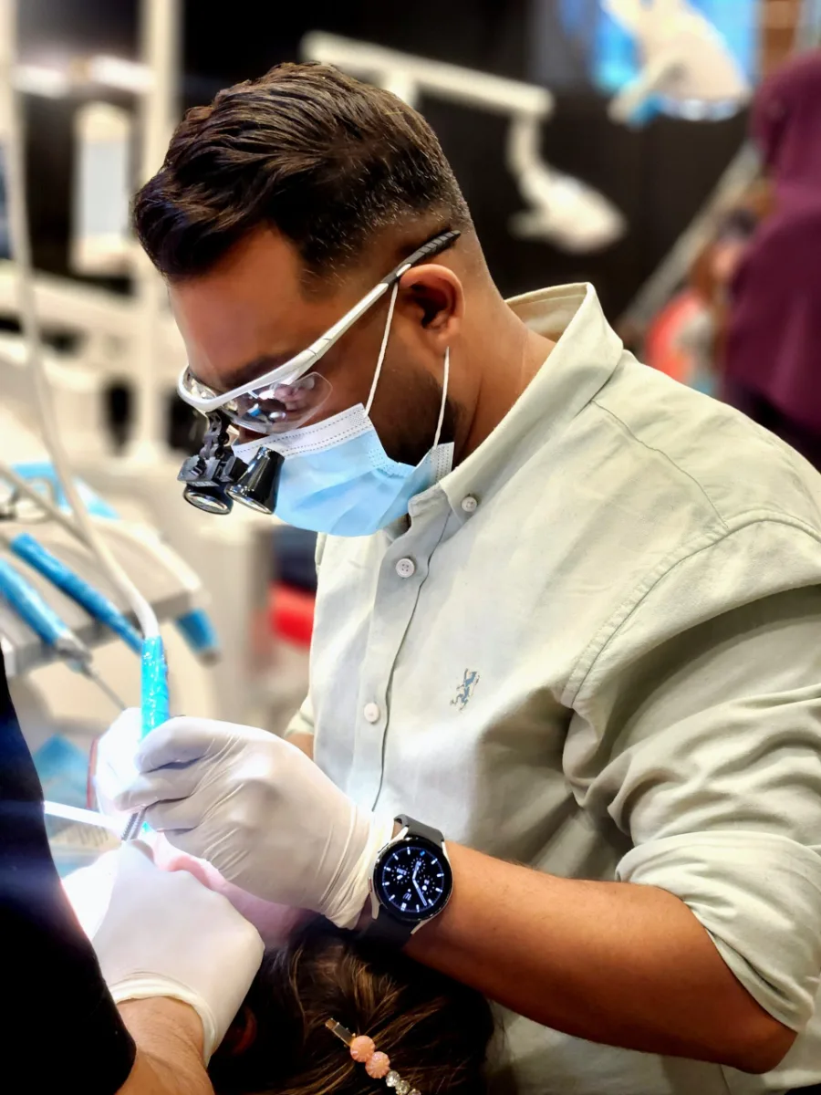 Dr. Ali Rashid treating a patient using dental loupes